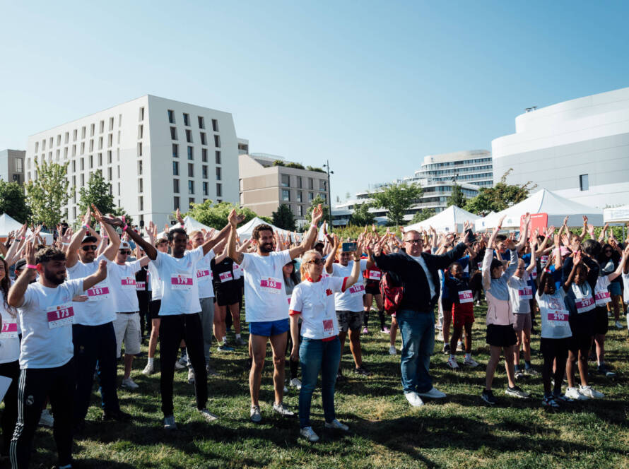 Échauffement collectif des participants lors d'une course solidaire Défi Enfance